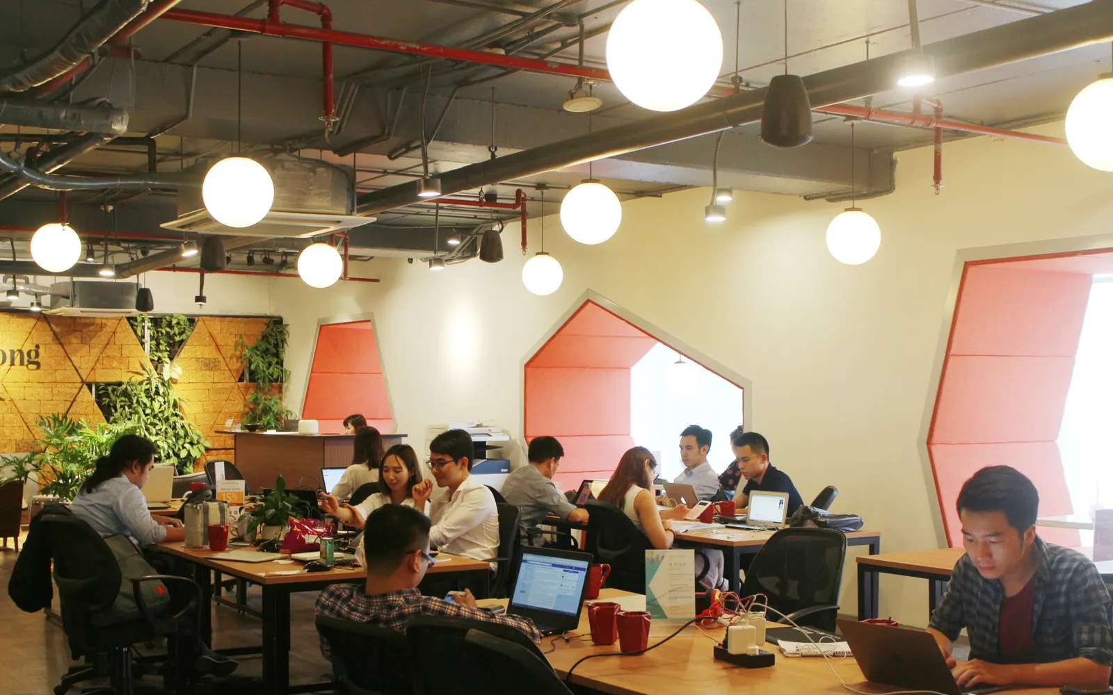 People working at shared desks in a busy coworking space