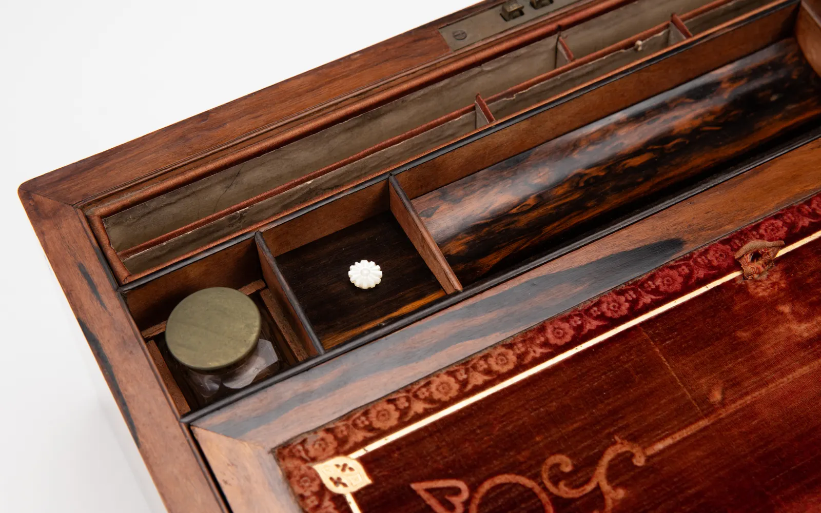 An antique writing box opened to show its compartments and leather writing surface