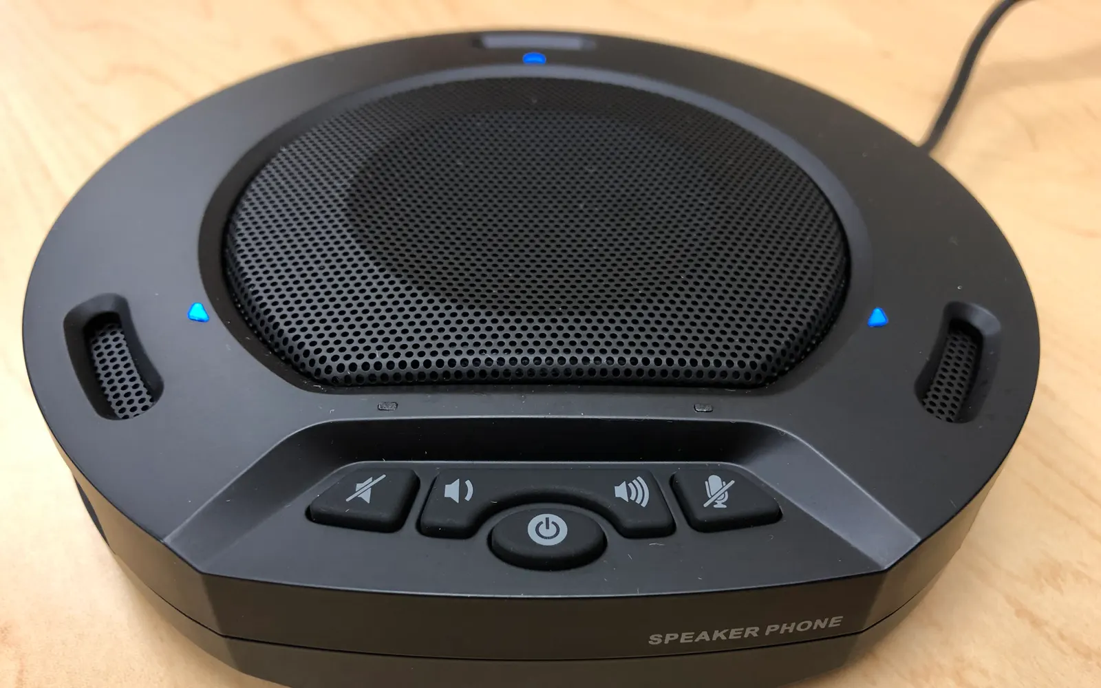A conference speakerphone sitting on a desk