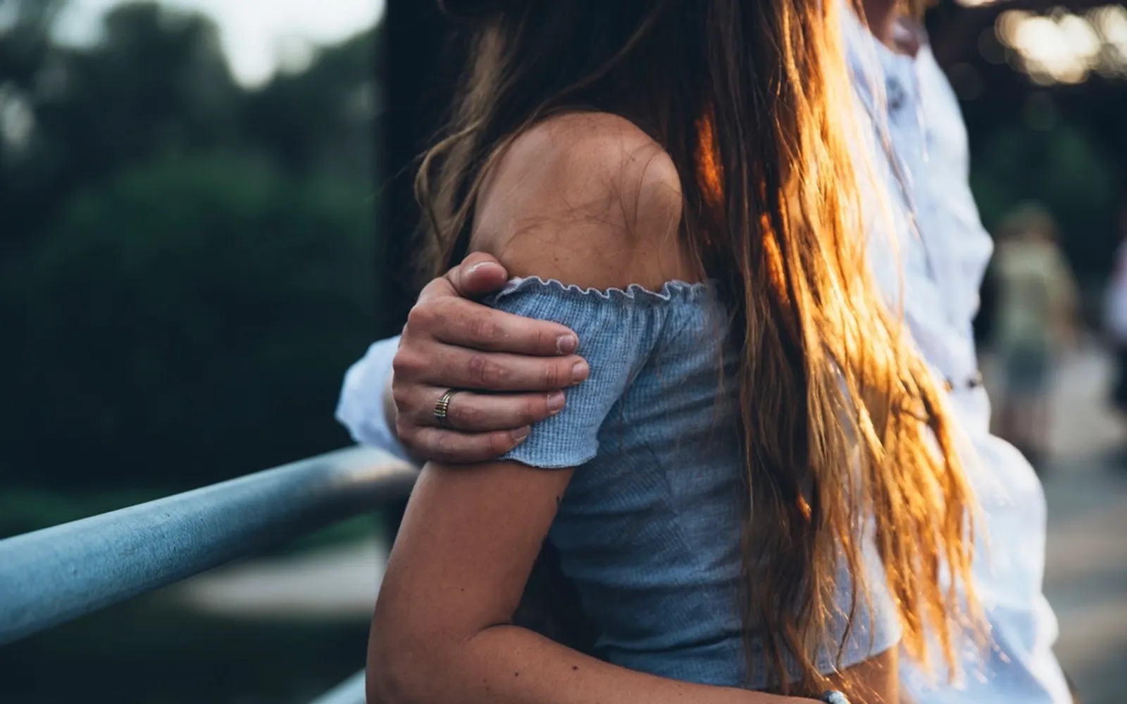 Someone resting a hand on a friend's shoulder in a comforting gesture