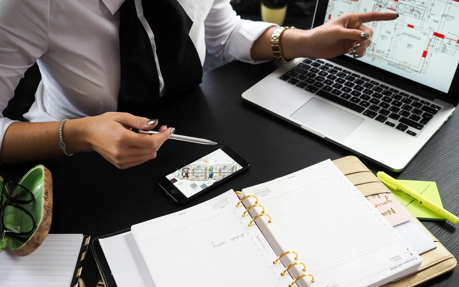 Two people going through a planner together at a desk with a tablet